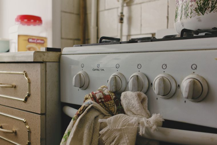 Vieille cuisinière blanche avec un torchon accroché à la poignée du four