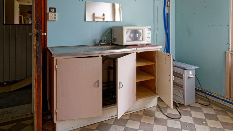 Cuisine ancienne aux placards ouverts sous l'évier