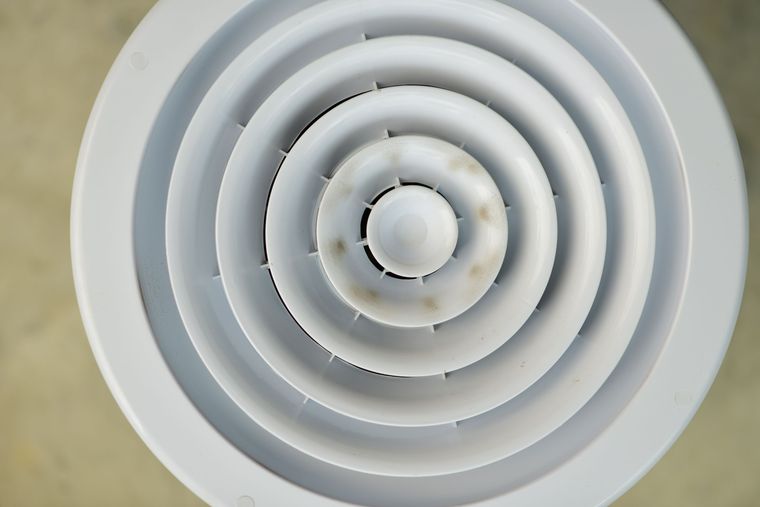Bouche d'aération ronde au plafond, légèrement encrassée