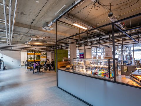 Grande cafétéria aux tables en bois et au plafond industriel