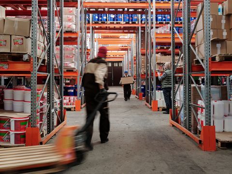 Allée d'entrepôt entre des rayonnages chargés de cartons