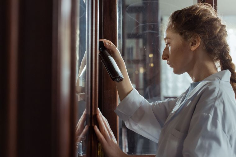 Femme inspectant de près l'intérieur d'un placard vitré